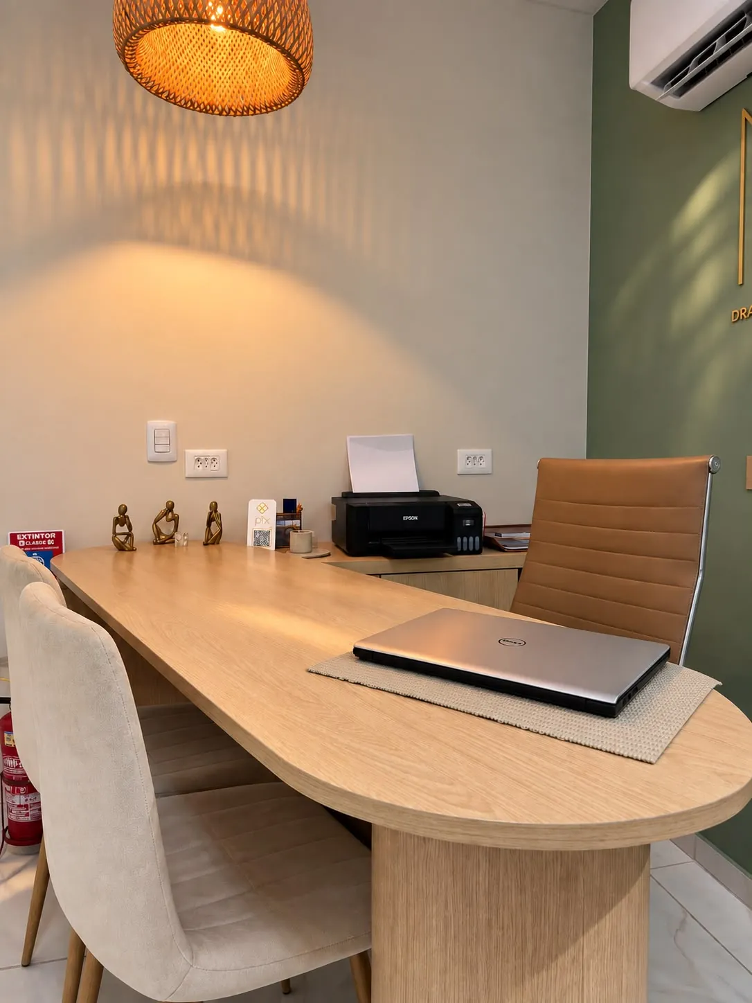Mesa de madeira com cadeiras para o paciente, onde acontece a conversa da consulta